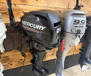 Mercury 20HP FourStroke outboard motor displayed beside Honda 9.9 and other brands on wooden mount at Y Marina showroom