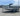 Smoker Craft fishing boat on trailer with Yamaha motor, bimini top up, parked in dealership lot under sunny sky