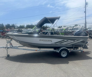 Smoker Craft fishing boat on trailer with Yamaha motor, bimini top up, parked in dealership lot under sunny sky