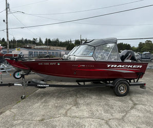 Red Tracker Pro V-175 fishing boat with Mercury motor on trailer, labeled OR 186 AFT, parked on lot under cloudy sky