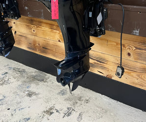 Close-up of a black boat outboard motor mounted on a wood-paneled wall at Y Marina